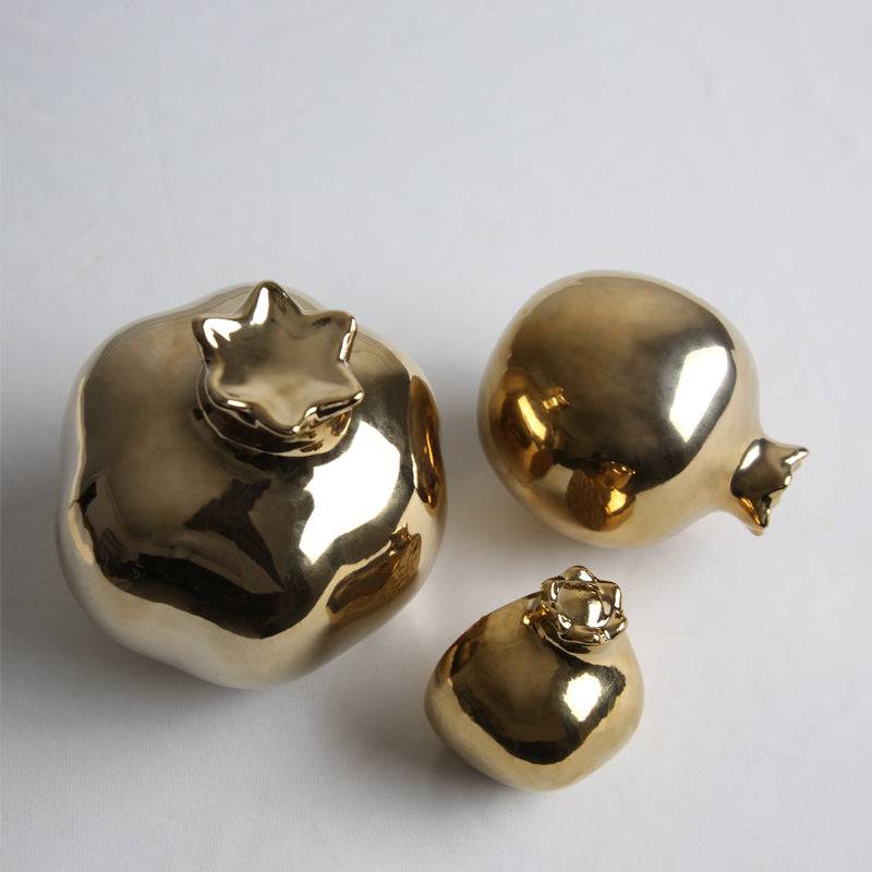 Golden pomegranate home decor figurine by BEACON, decorative gold-colored ornament for stylish interior accents.