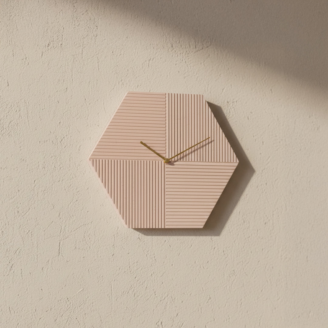 Beige hexagon wall clock with black hands and hour markers, modern design by BEACON for stylish home decor.