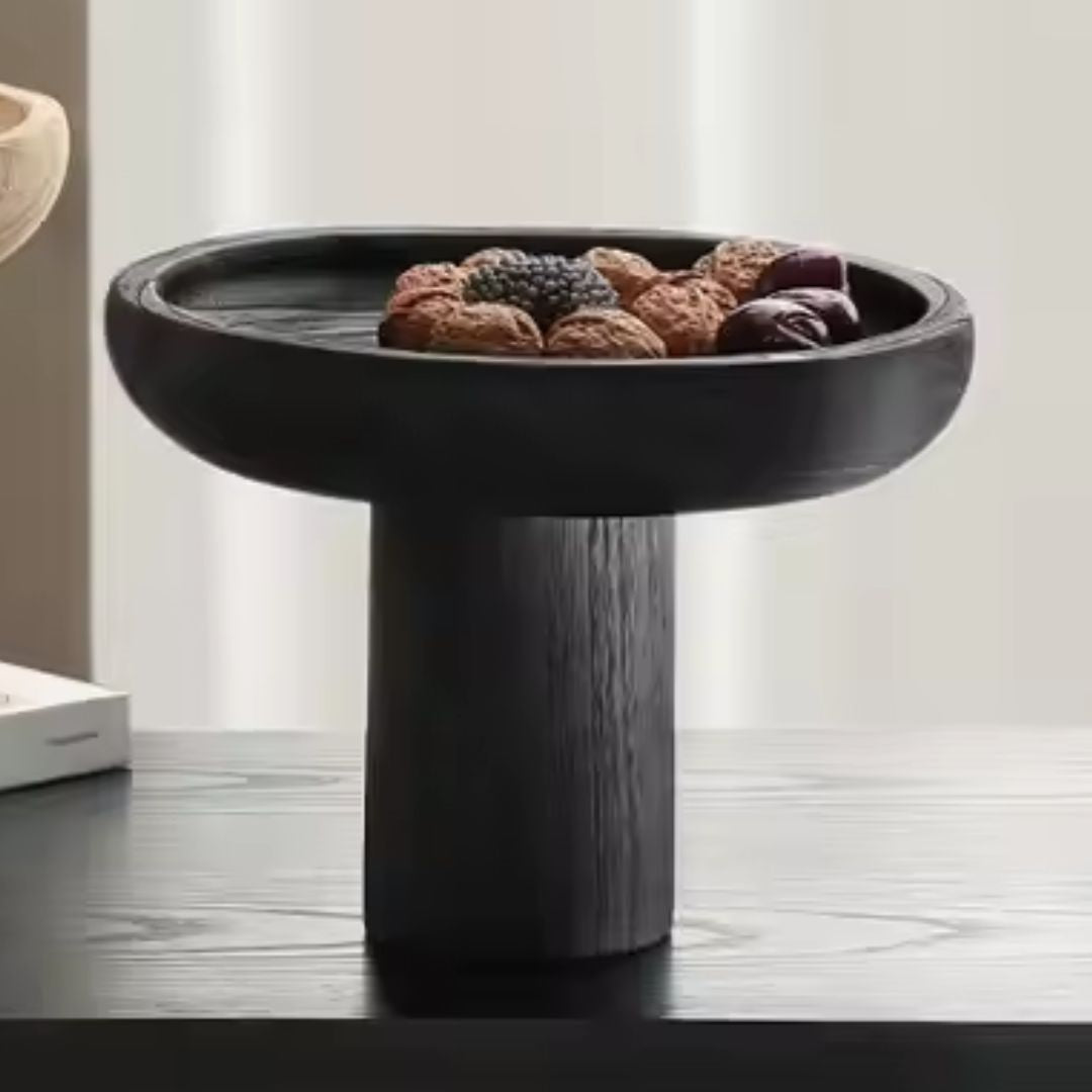 Black high-legged wooden fruit bowl by BEACON, with a sleek design perfect for displaying fresh fruit.