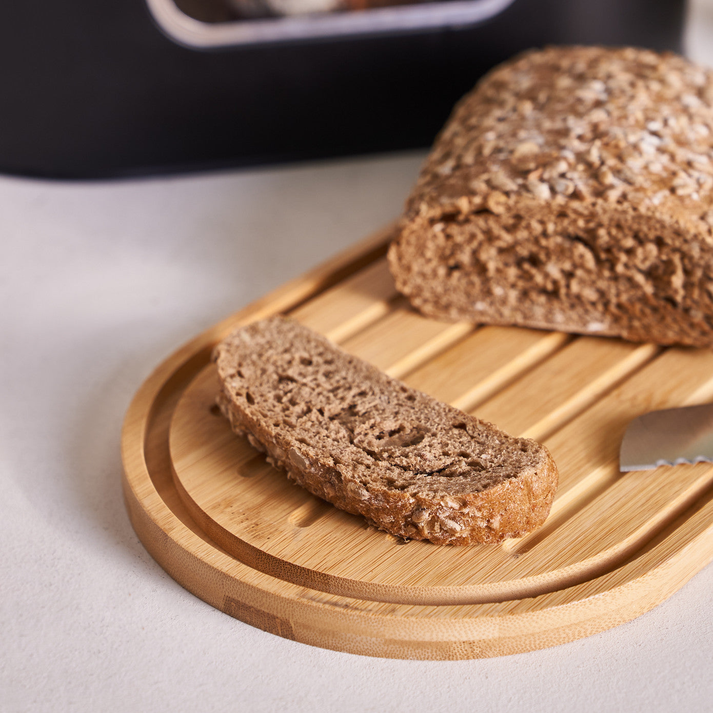 Black Karaca Stream 2-in-1 bread box and cutting board, made of durable material, with a sleek design for kitchen storage and prep.