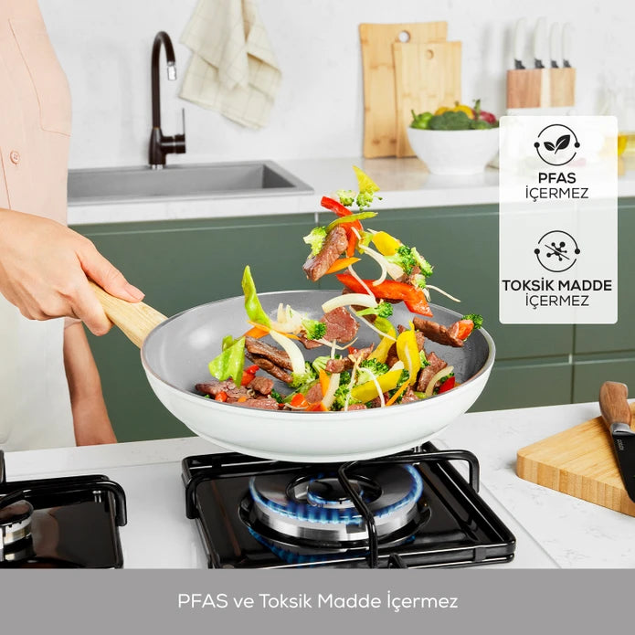 Karaca Swiss Crystal Nature Pro 7-piece cookware set with stainless steel pots and pans, glass lids, and ergonomic handles.