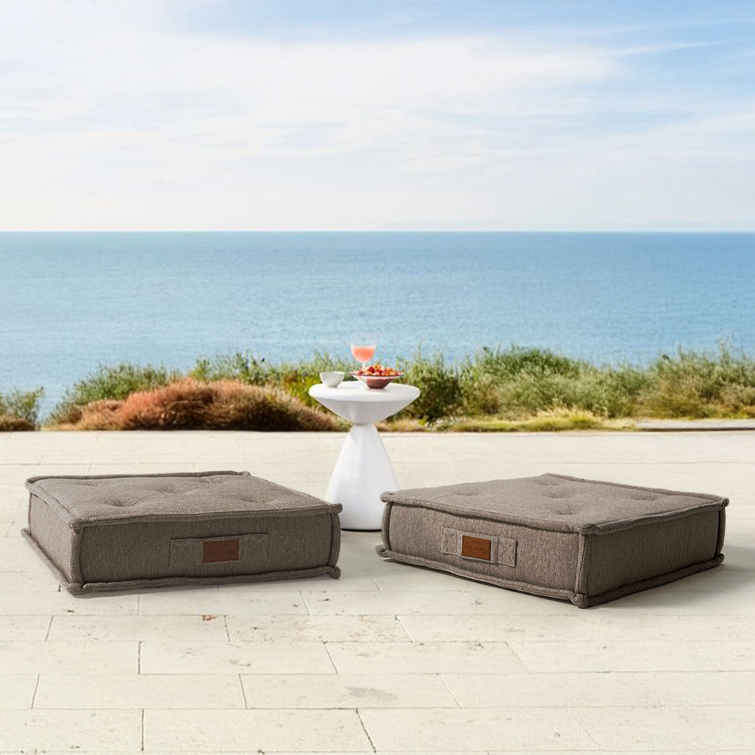 Brown La Concha pouf with compressed foam from BEACON, showcasing its round, cushioned design and textured fabric surface.