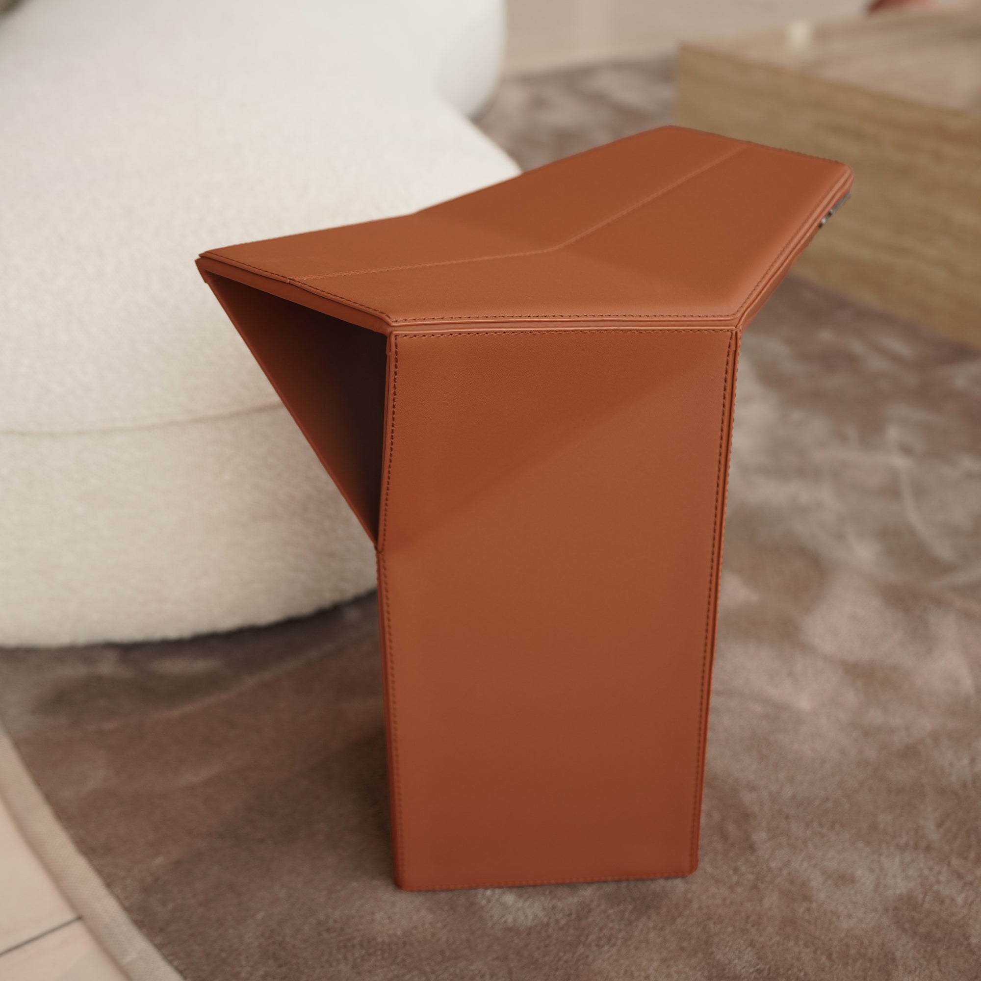 Orange microfiber saddle leather side table and low stool from BEACON, versatile pouf with stylish, soft cushioning.