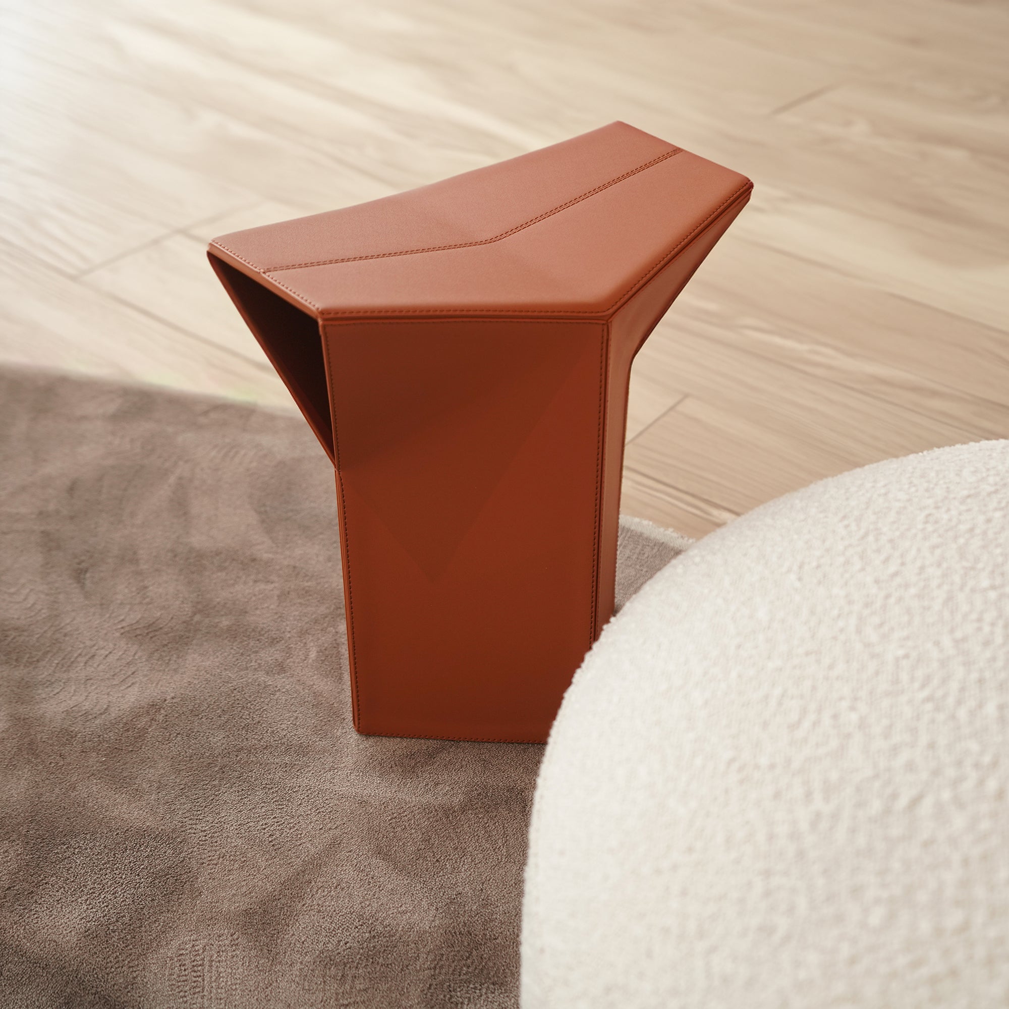 Orange microfiber saddle leather pouf side table and low stool by BEACON, versatile and stylish for living spaces.