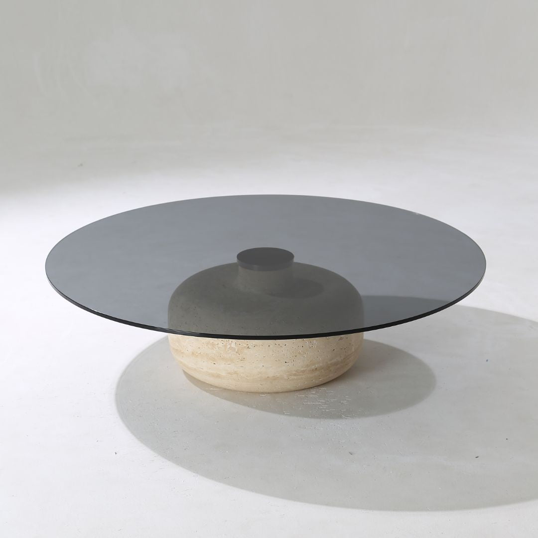 Minimal grey glass and travertine marble round coffee table by BEACON, showcasing sleek modern design and smooth surface.