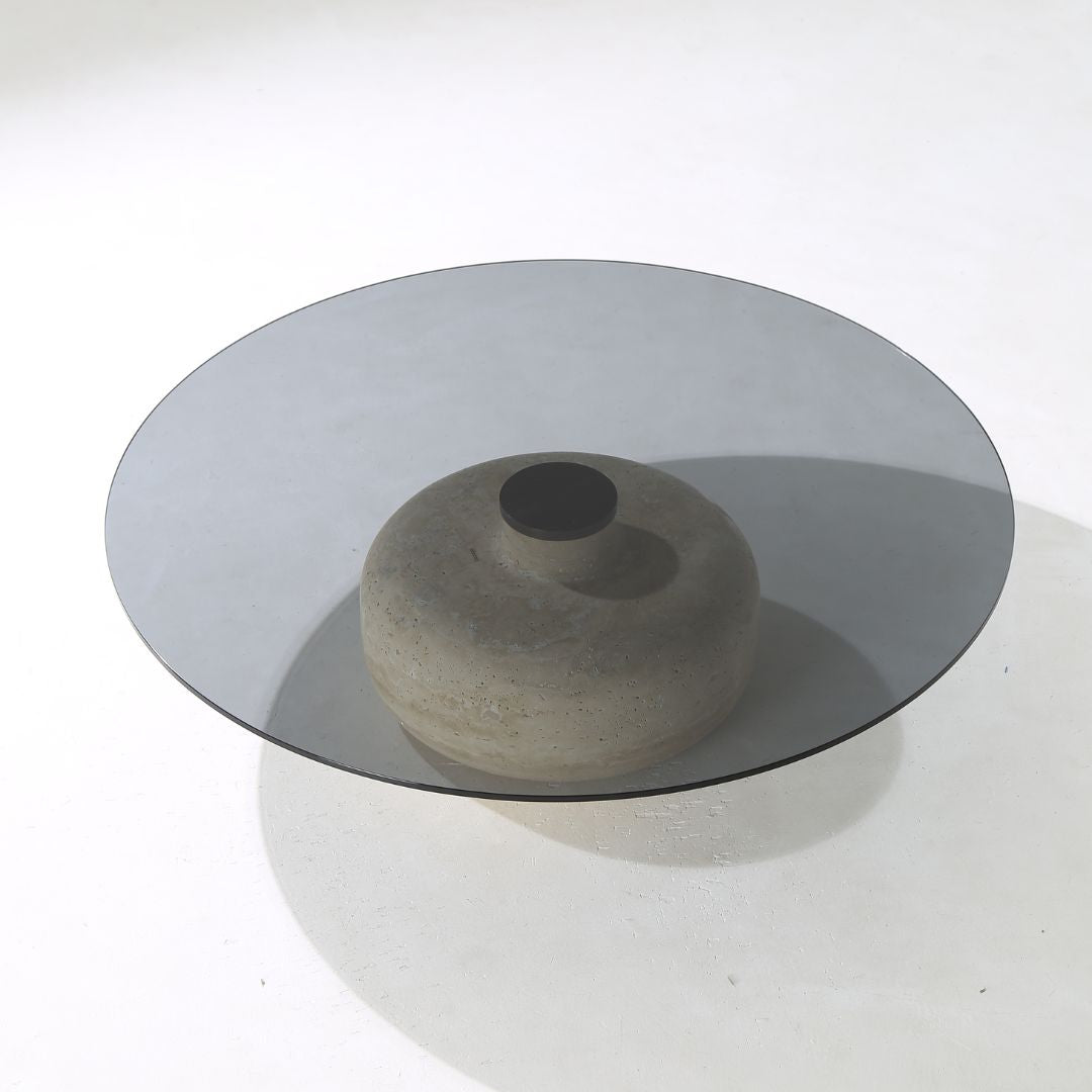 Minimal grey glass and travertine marble round coffee table by BEACON, modern design with sleek surface and sturdy base.