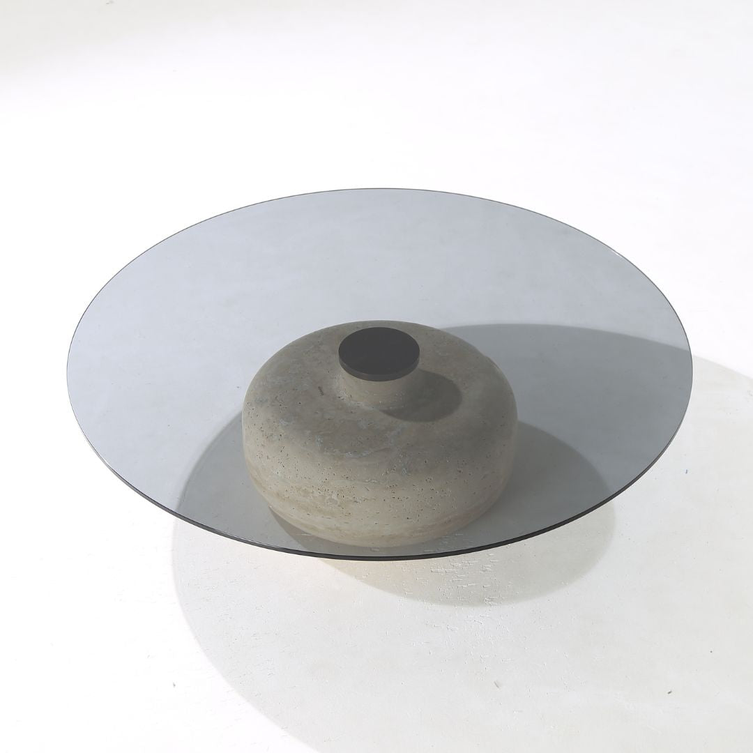 Minimal grey glass and travertine marble round coffee table by BEACON, modern design with sleek surface and sturdy base.