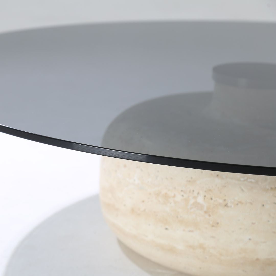 Minimal grey glass and travertine marble round coffee table by BEACON, showcasing a sleek modern design with smooth surfaces.