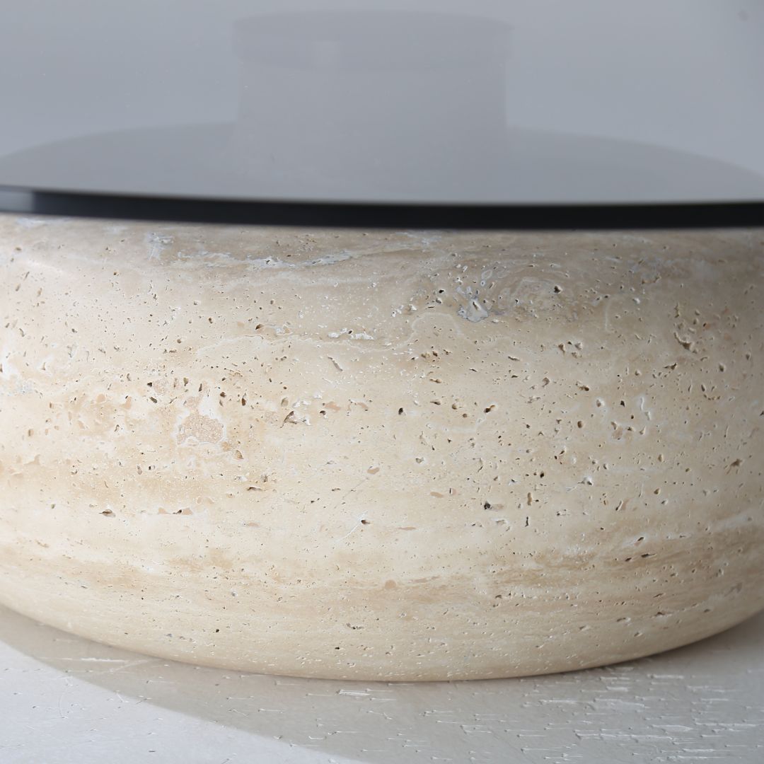 Minimal grey glass and travertine marble round coffee table by BEACON, showcasing a sleek modern design and smooth surface.