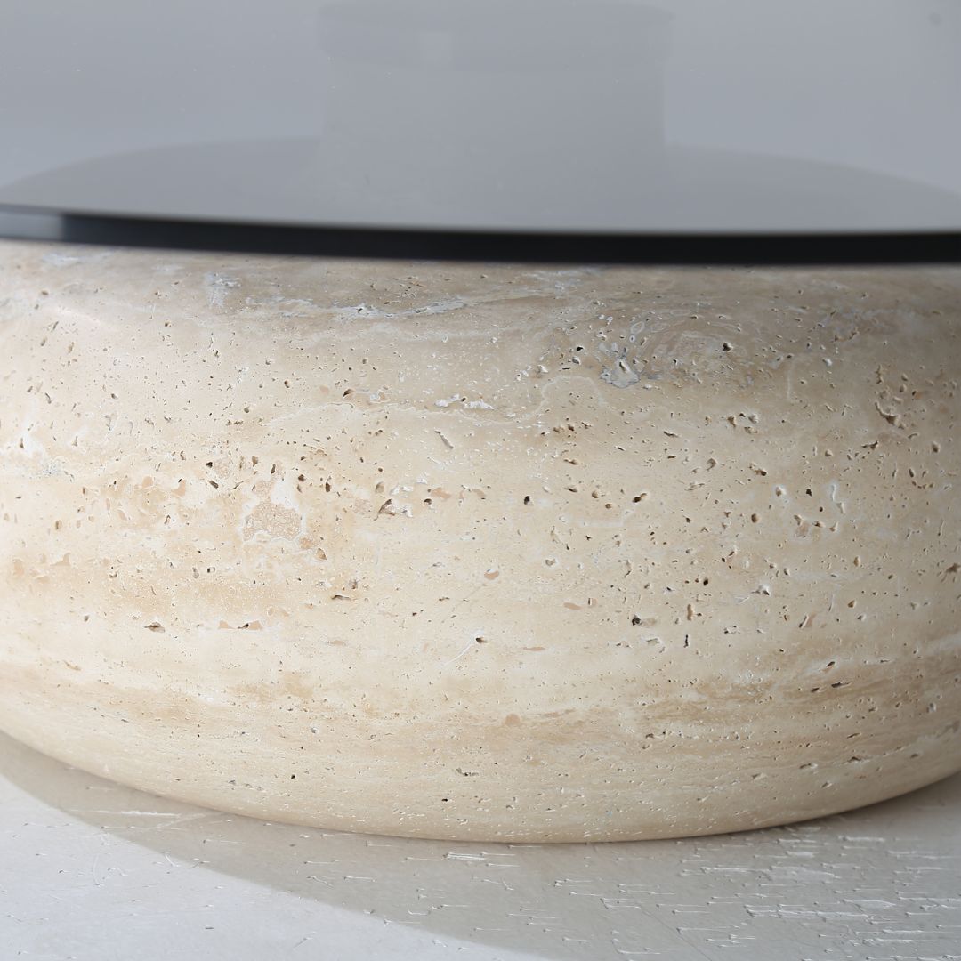 Minimal grey glass and travertine marble round coffee table by BEACON, featuring sleek modern design and smooth surface.