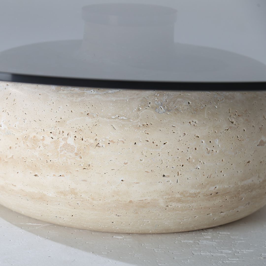 Minimal grey glass and travertine marble round coffee table by BEACON, showcasing sleek modern design and smooth surface.