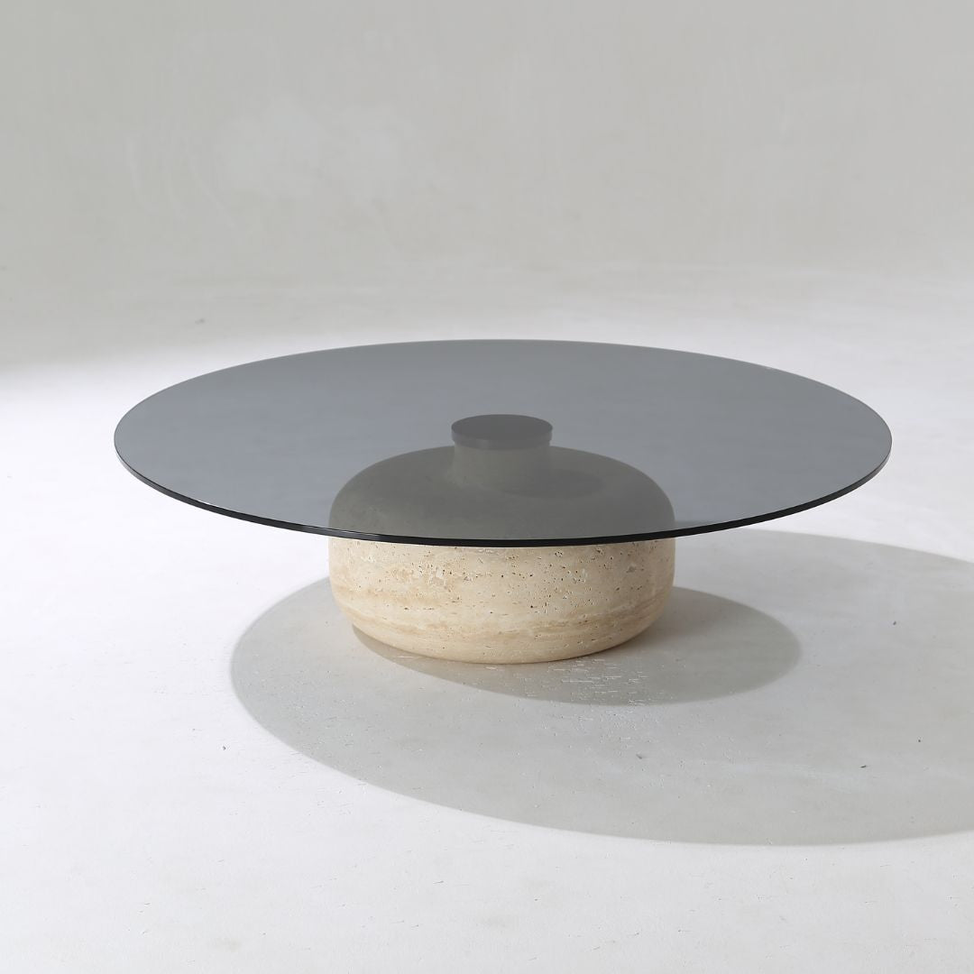 Minimal grey glass and travertine marble round coffee table by BEACON, modern design with sleek surface and sturdy base.
