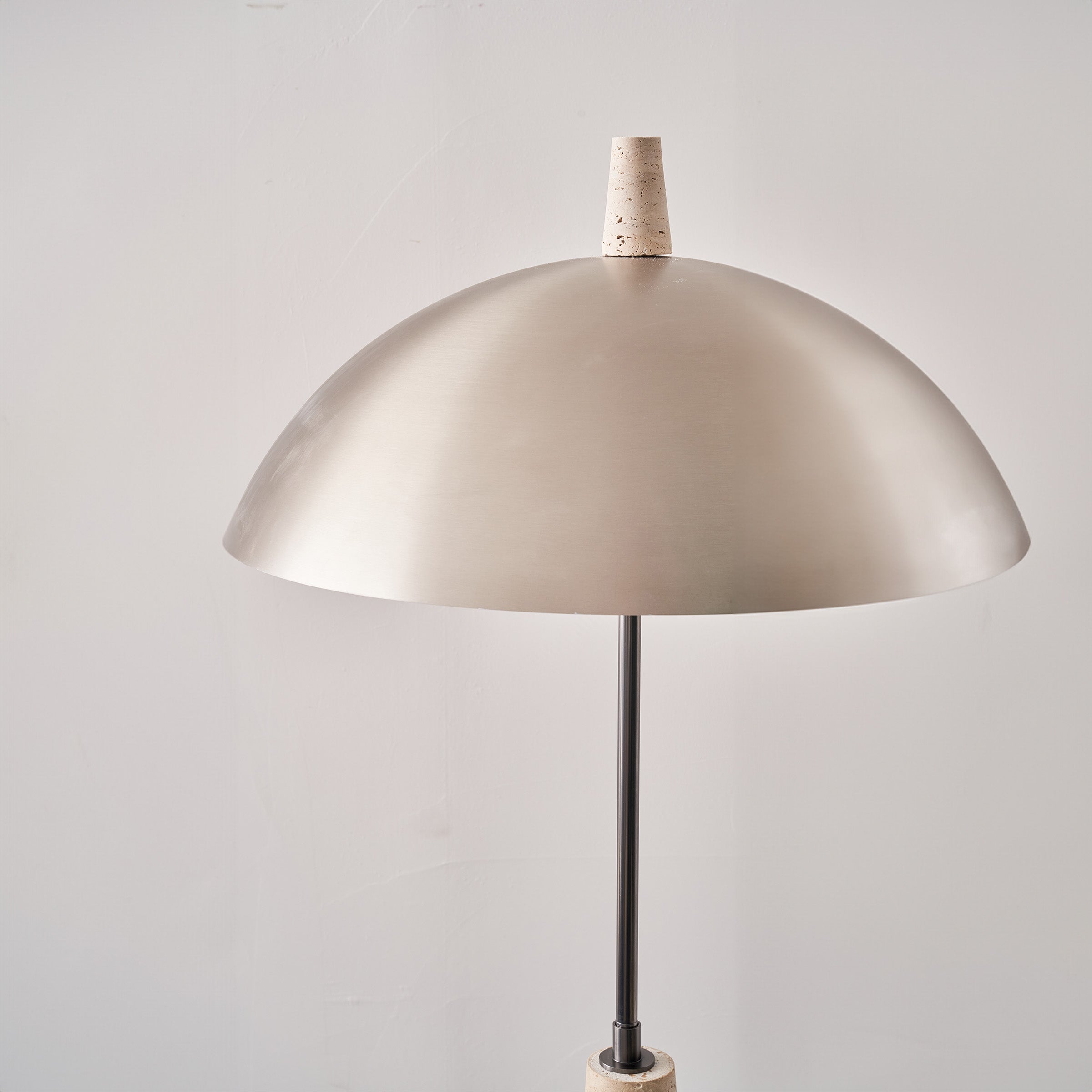 Natural travertine floor lamp by BEACON with a sleek, modern design, featuring a textured stone base and a tall, elegant lampshade.