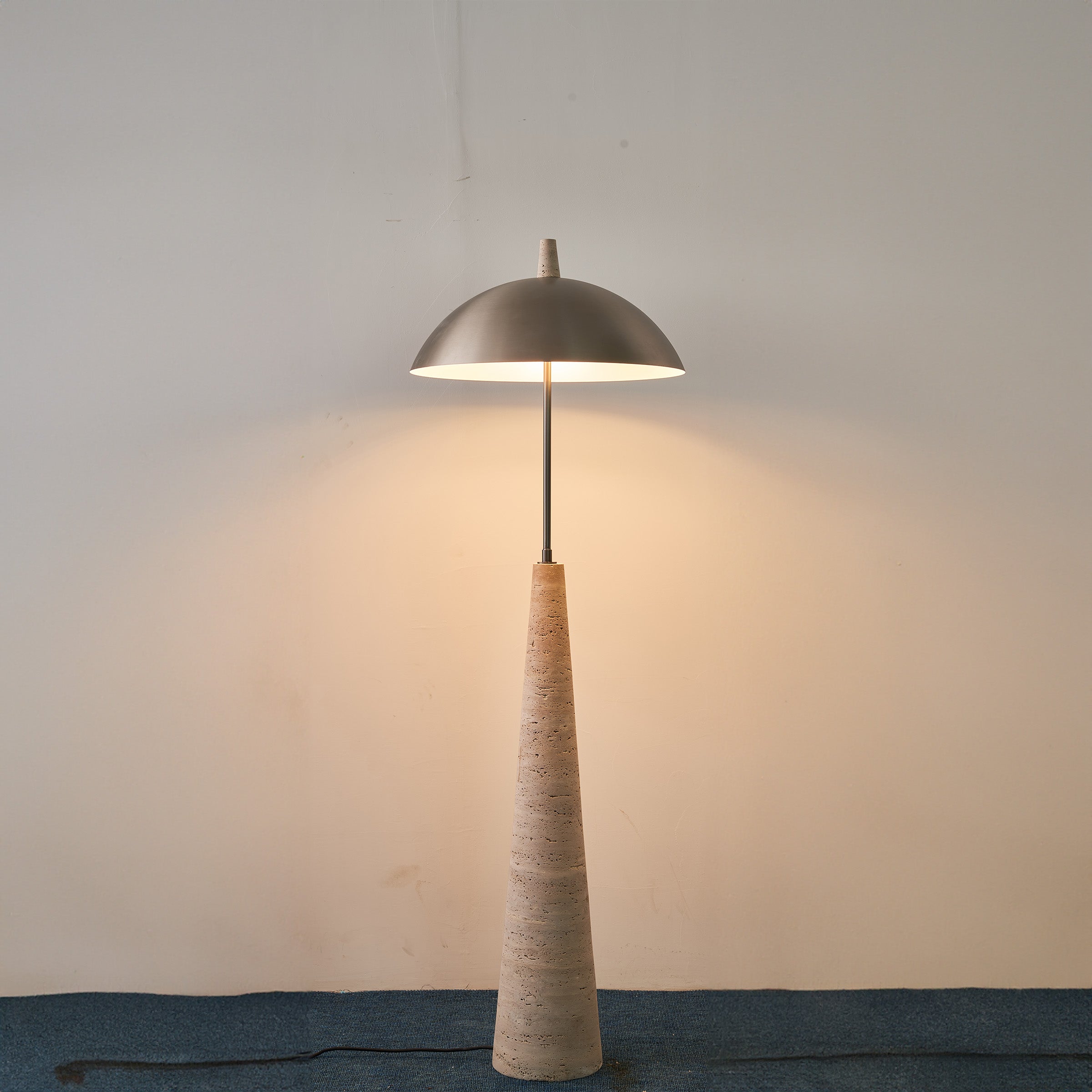 Natural travertine floor lamp by BEACON with a sleek, modern design, featuring a textured stone base and a tall, elegant lampshade.