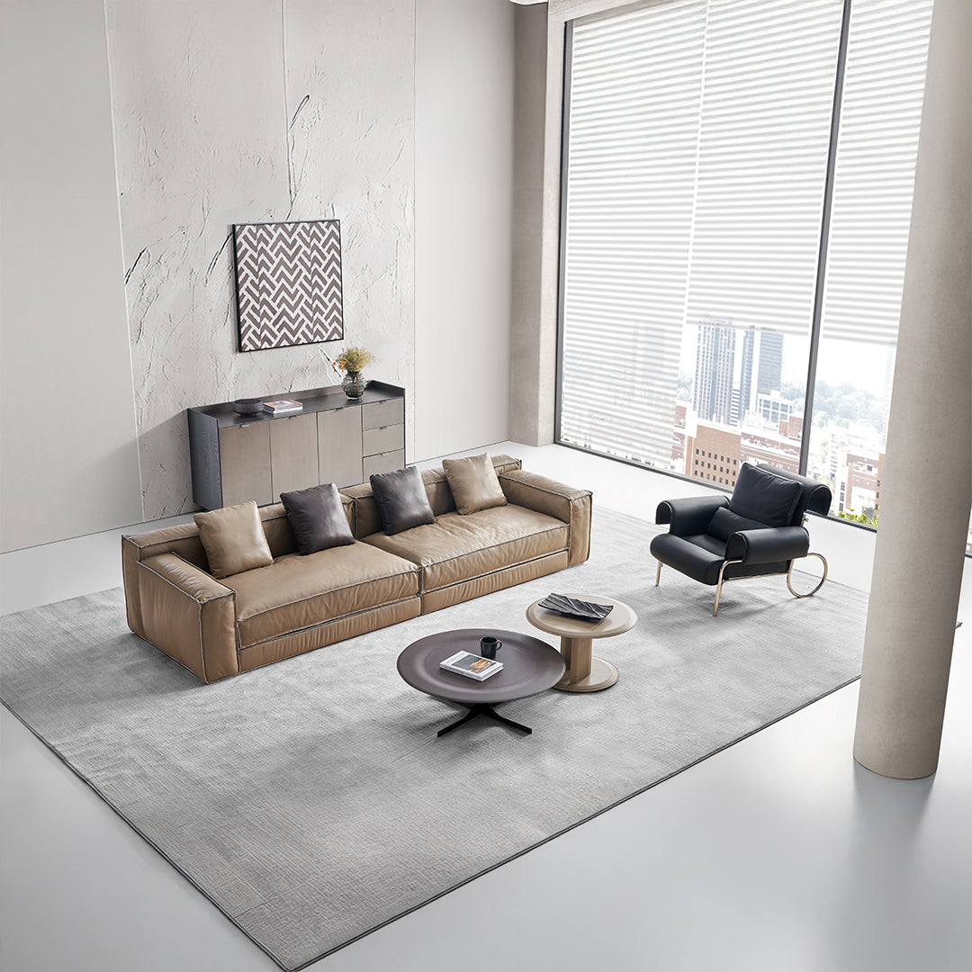 BEACON Orbit Lux brown saddle leather coffee table with sleek wooden legs and modern design in a living room setting.
