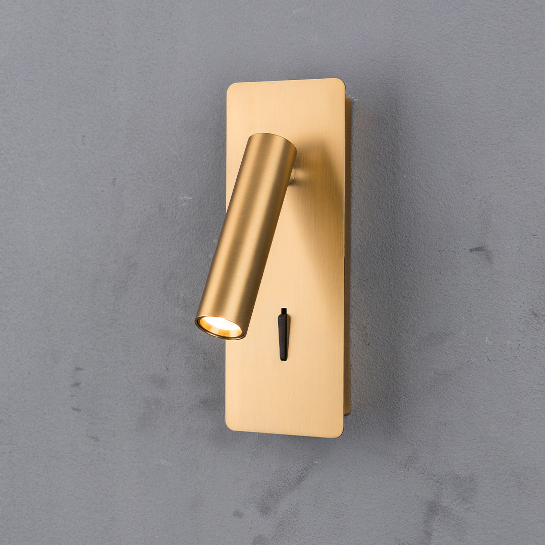 BEACON Gemini hotel style wall reading lamp mounted on headboard, with sleek design and adjustable arm in brushed bronze finish.