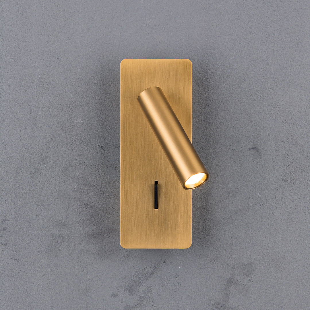 BEACON Gemini hotel-style wall reading lamp mounted on headboard with brass finish, designed for bedside or wall lighting.