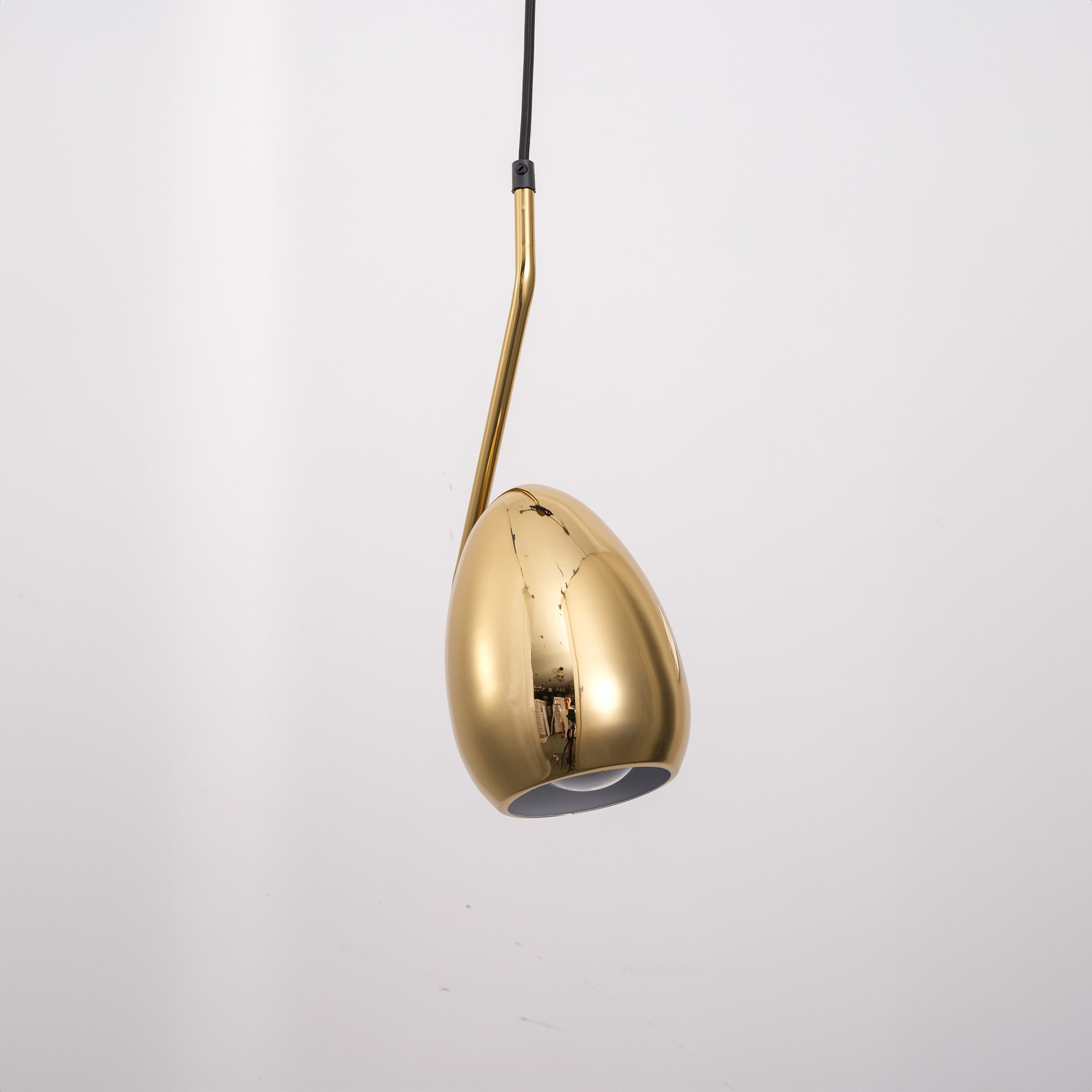 Gold teardrop pendant lamp from BEACON, featuring a sleek design and shiny finish, hanging with a modern aesthetic.