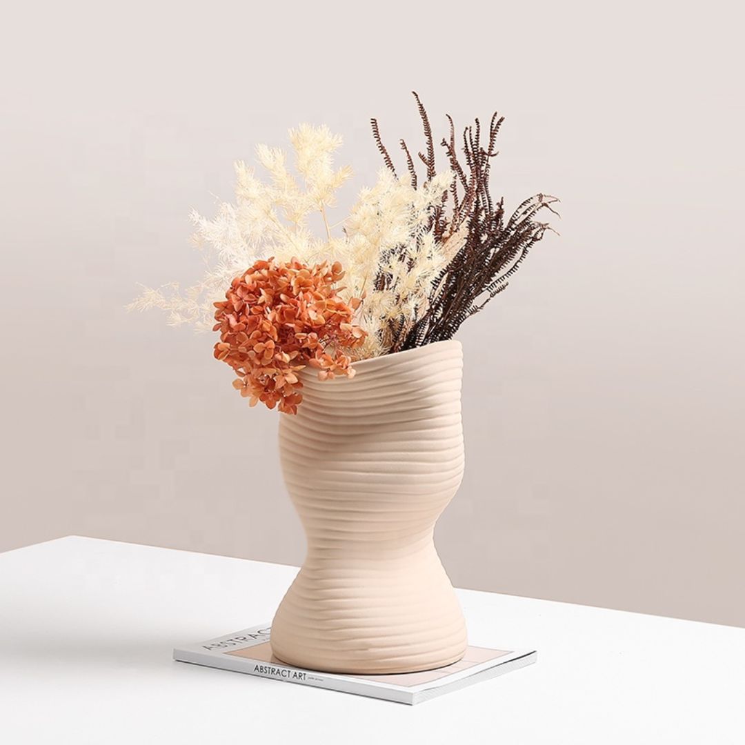 Beige vertical curved vase by BEACON, made of ceramic, with a sleek, modern design perfect for home decor.