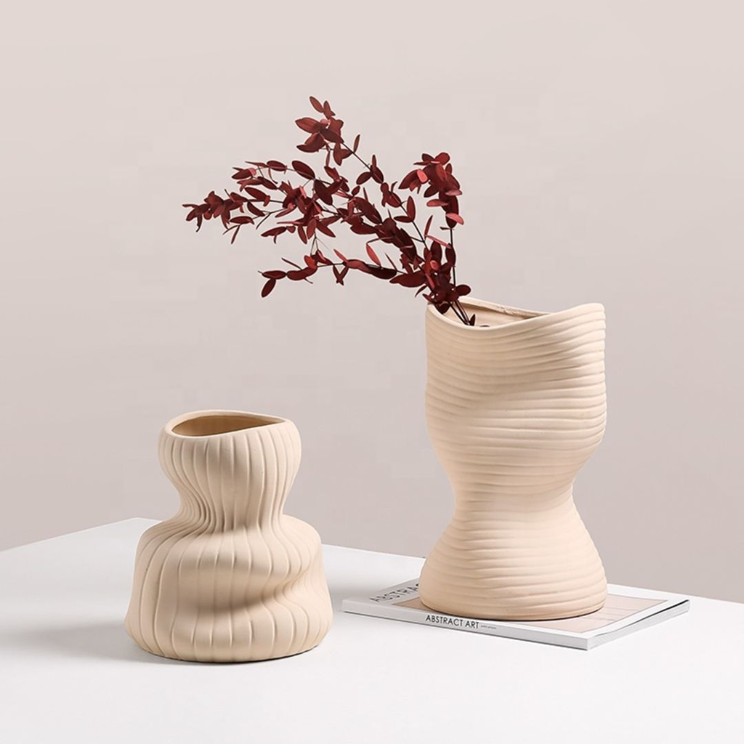 Beige vertical curved vase by BEACON, featuring a sleek, modern design ideal for decorative floral arrangements.