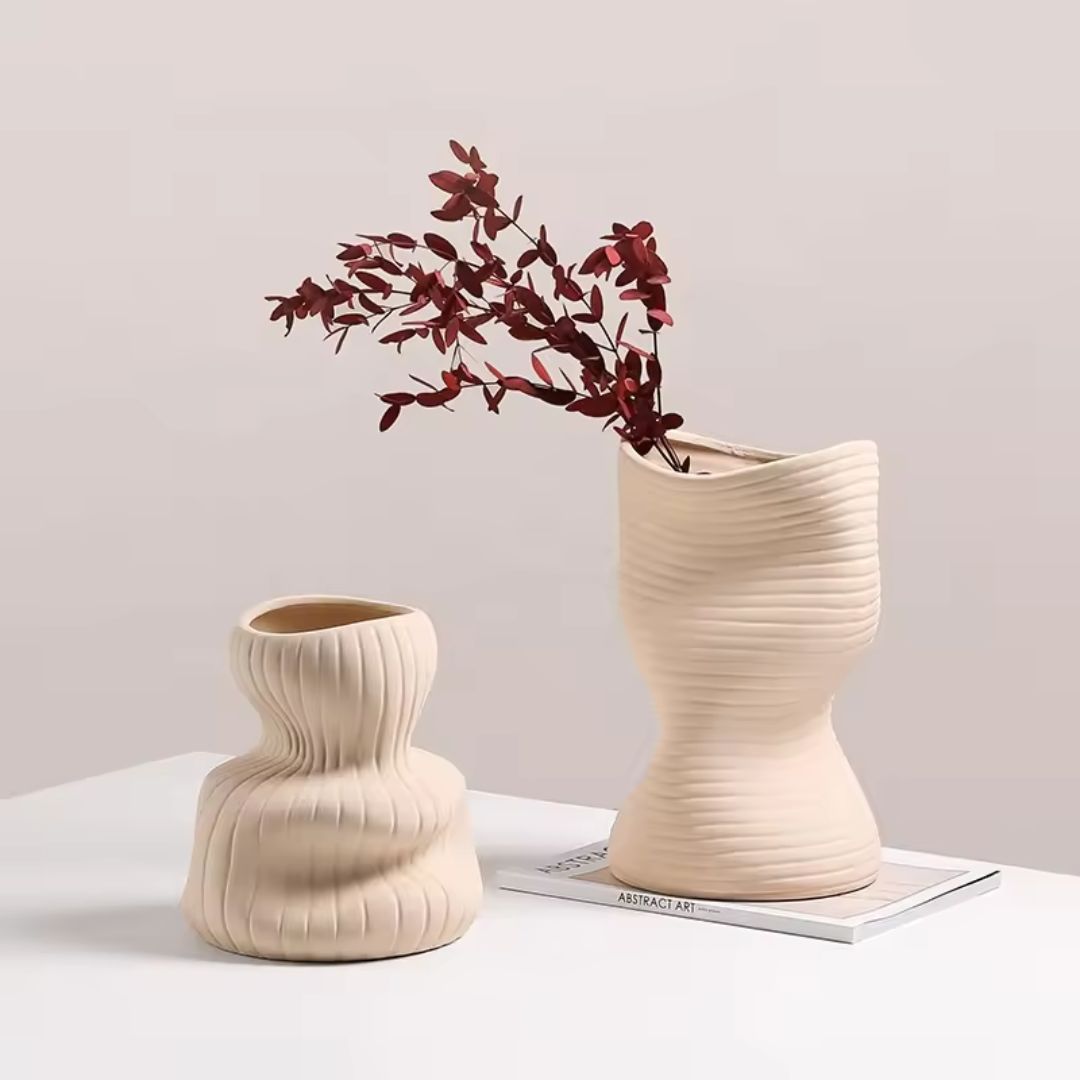 Beige vertical curved vase by BEACON, made of ceramic, with a sleek modern design, ideal for displaying flowers or decor.