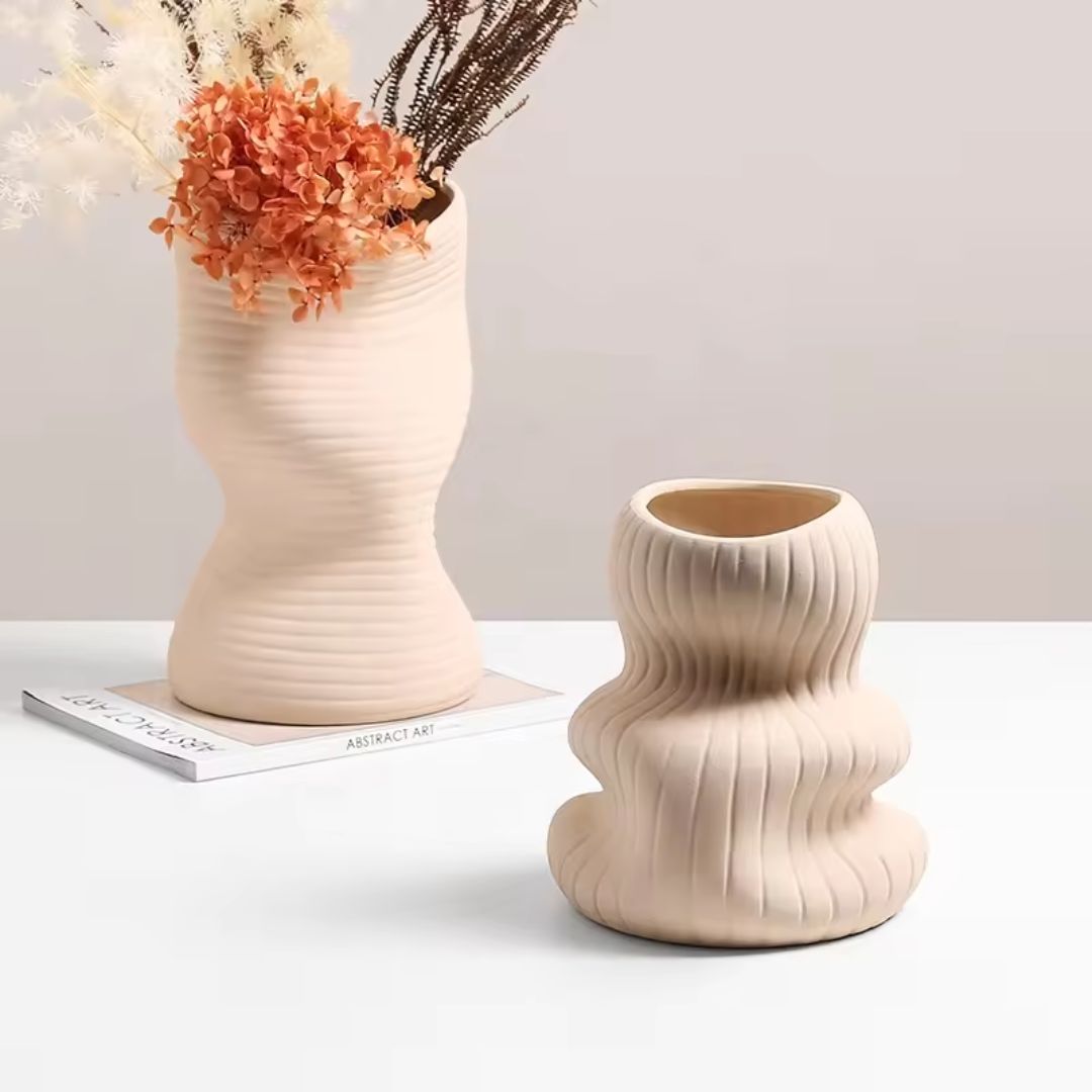 Beige vertical curved bottle vase by BEACON, with smooth curved design and narrow opening, perfect for floral arrangements.
